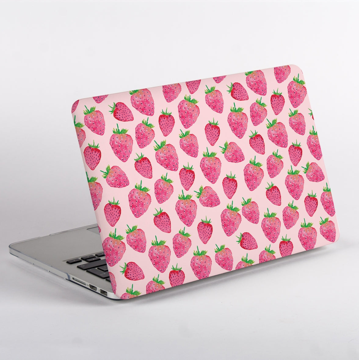 Laptop with a strawberry patterned case on a light gray background