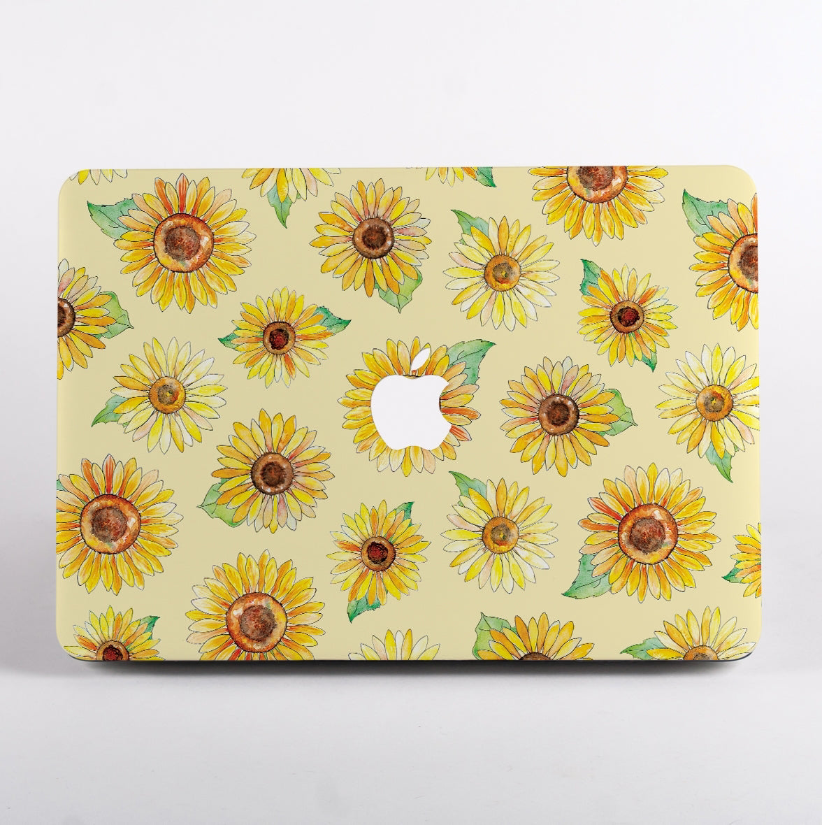 MacBook with sunflower design case on a beige background