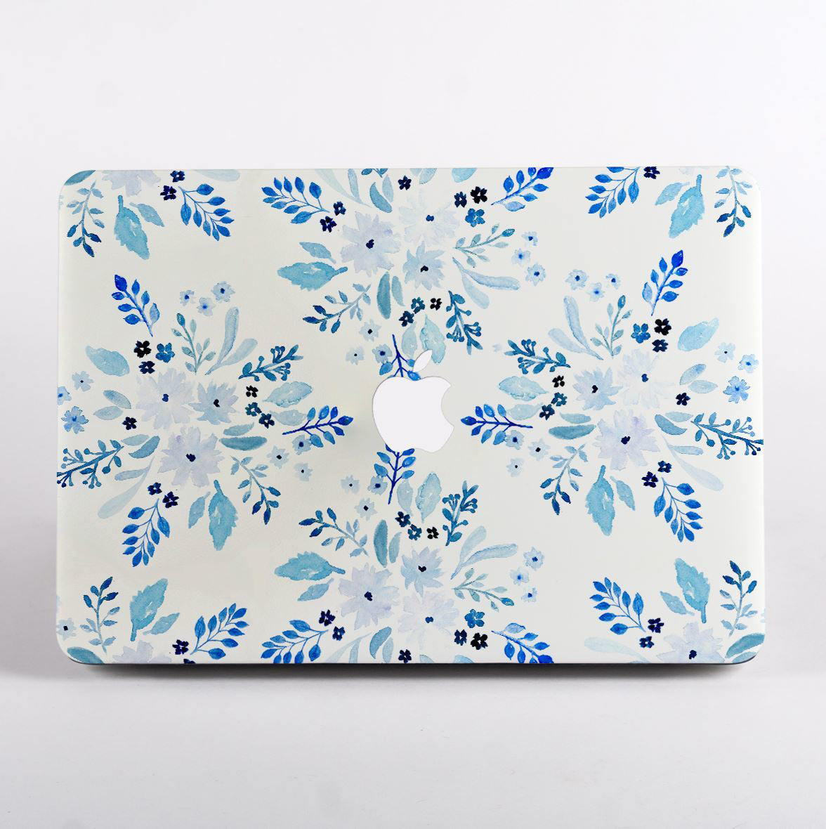MacBook with blue floral pattern case with logo on a white background