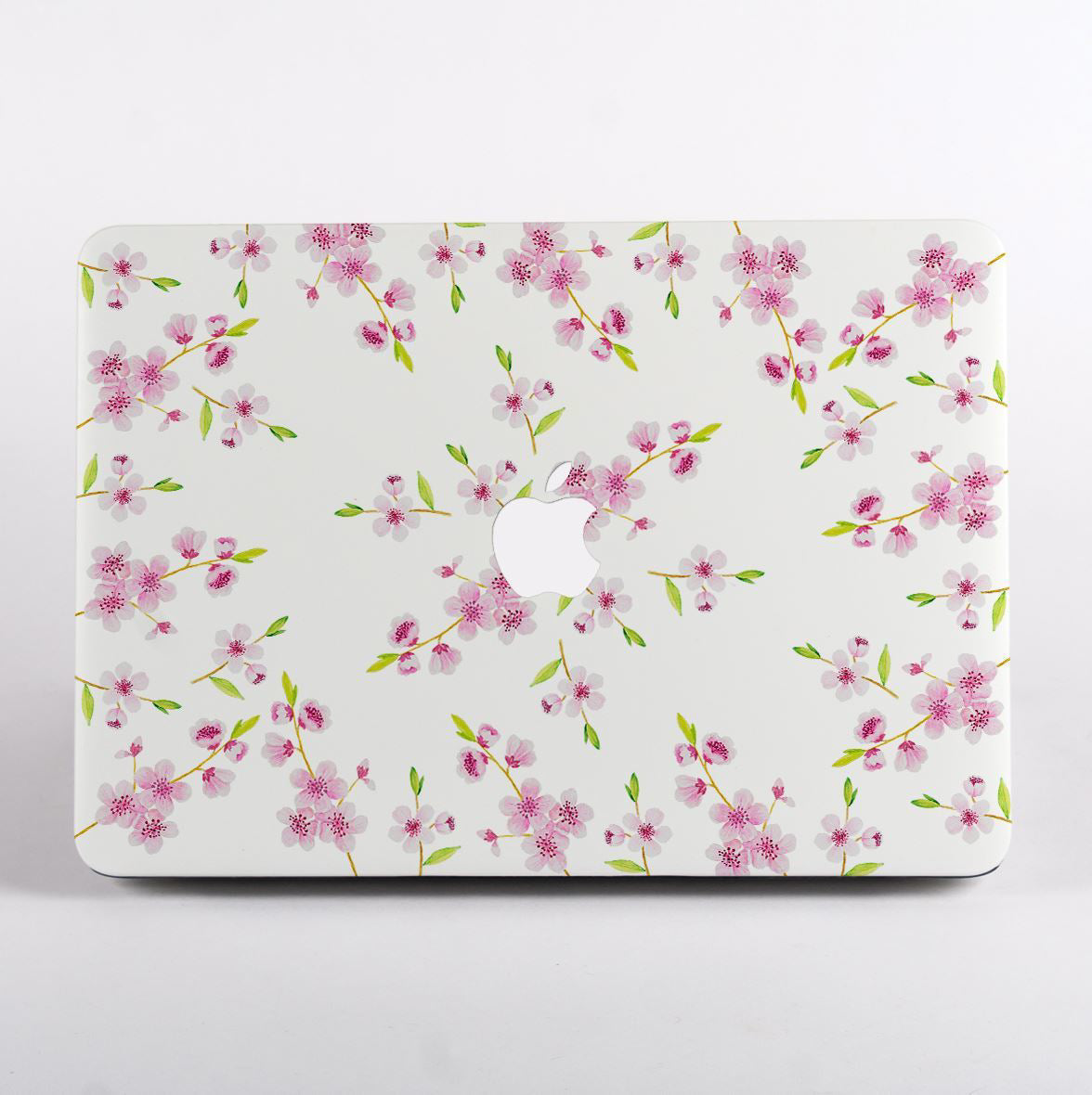 MacBook with a pink and white floral design case on a white background