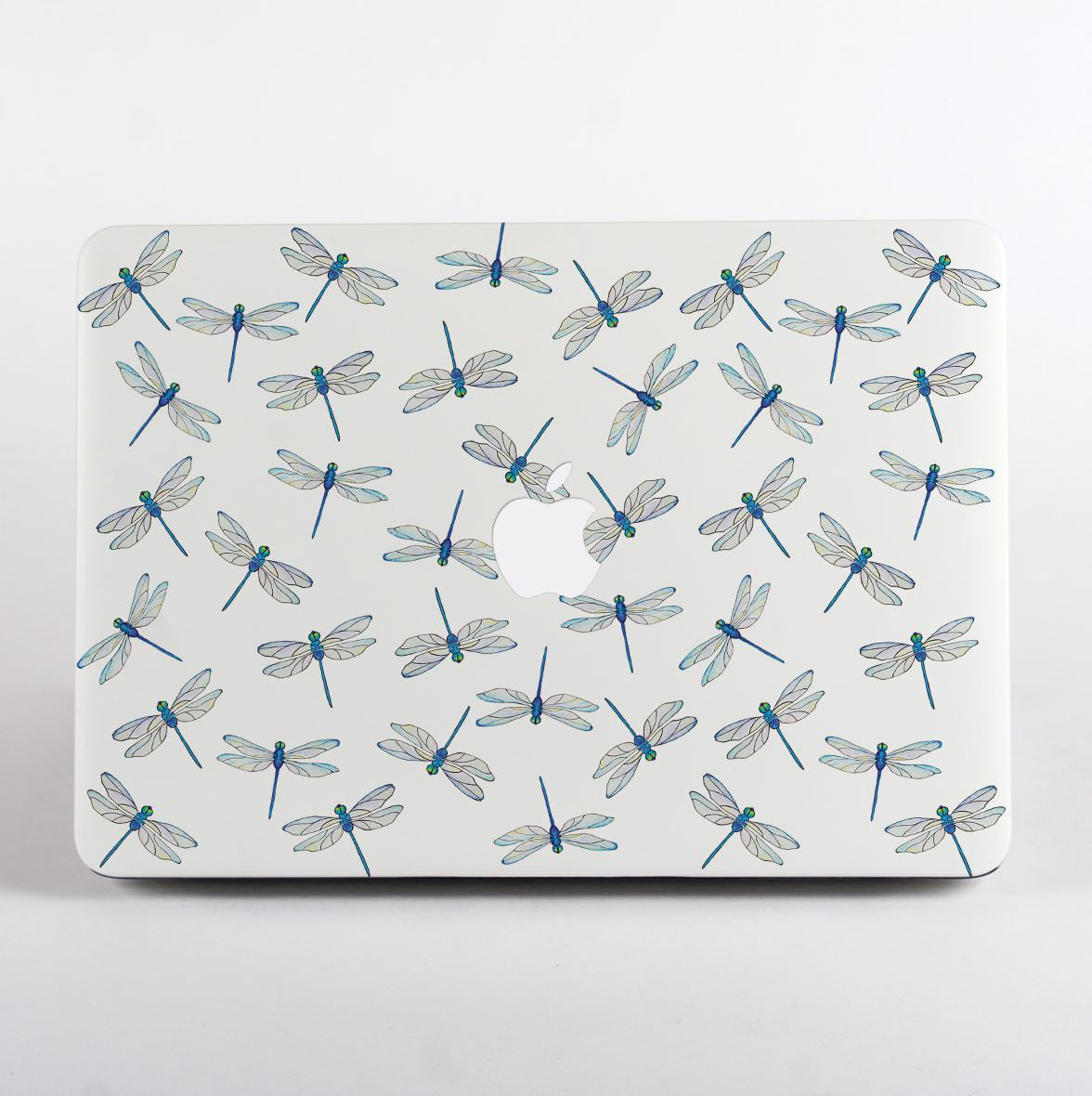 MacBook with dragonfly pattern case on a light gray background