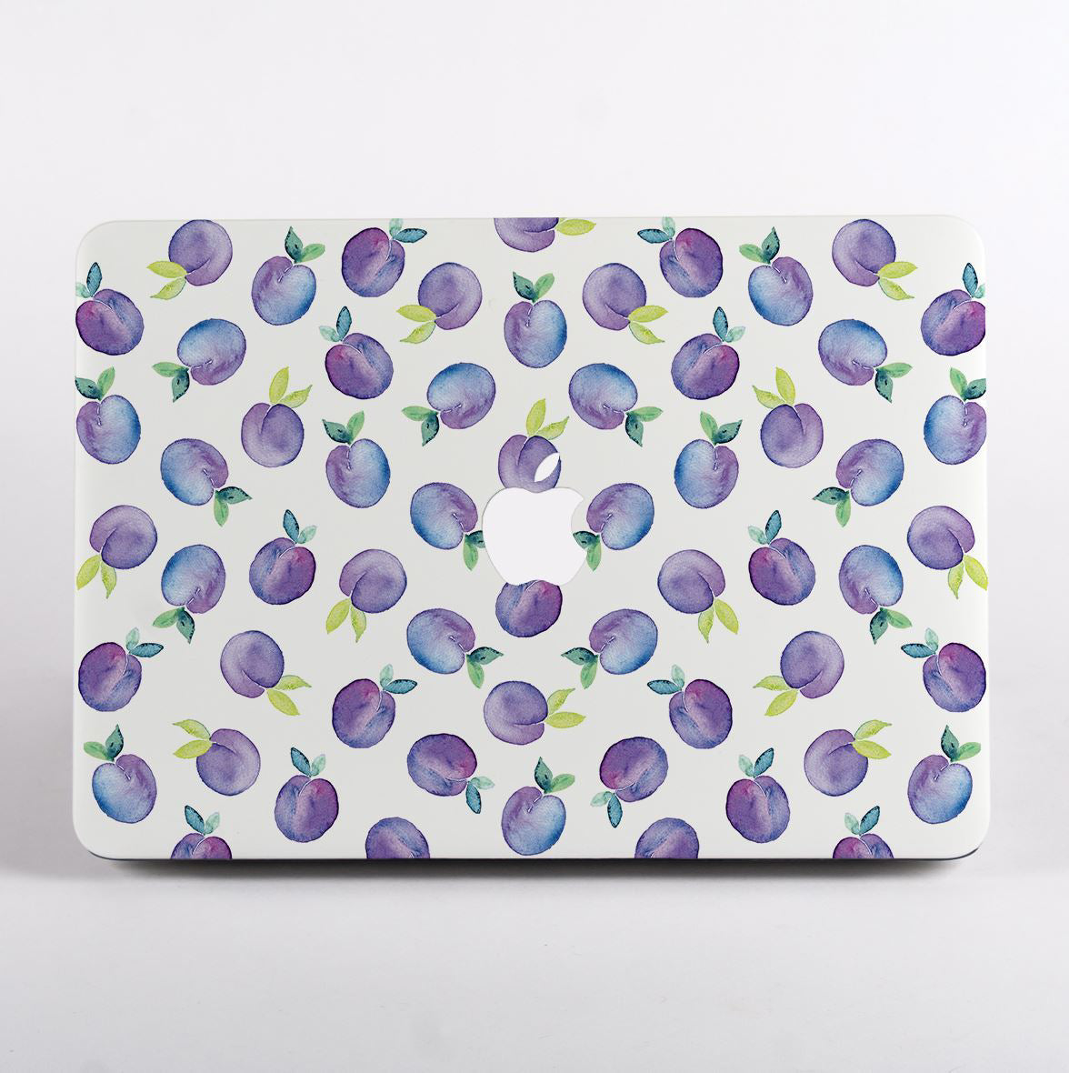 MacBook with a purple fruit pattern case on a white background