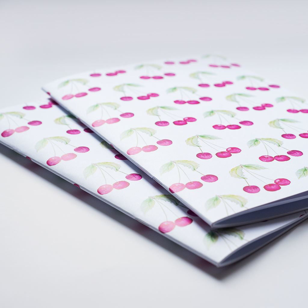 Two notebooks with cherry pattern on a white background