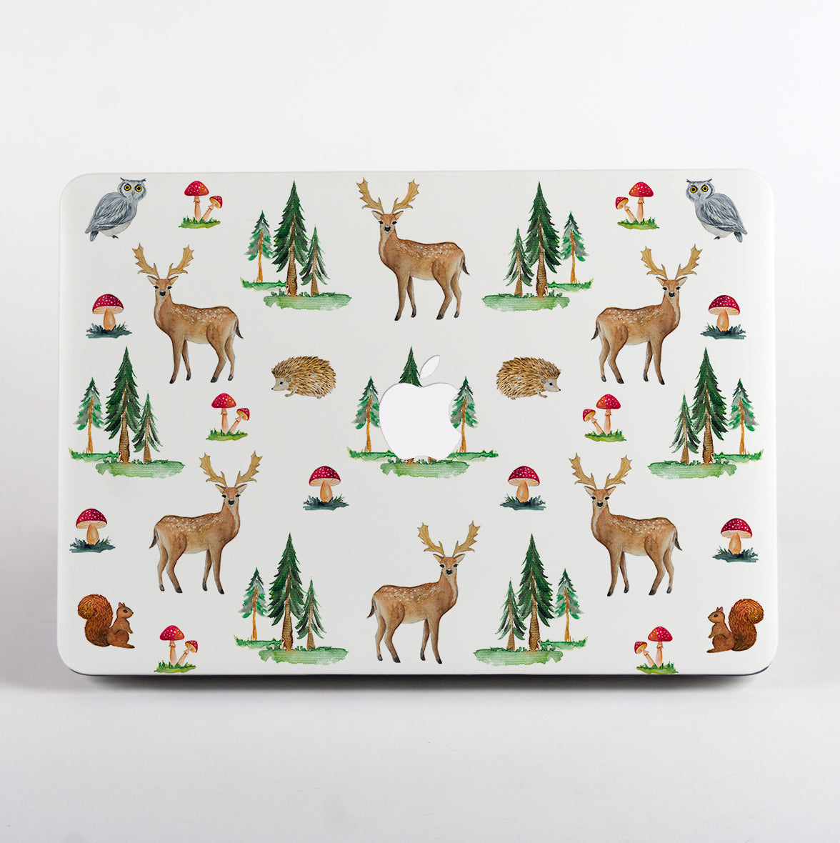 MacBook with a forest-themedMacBook Case featuring deer, trees, and mushrooms on a white background.