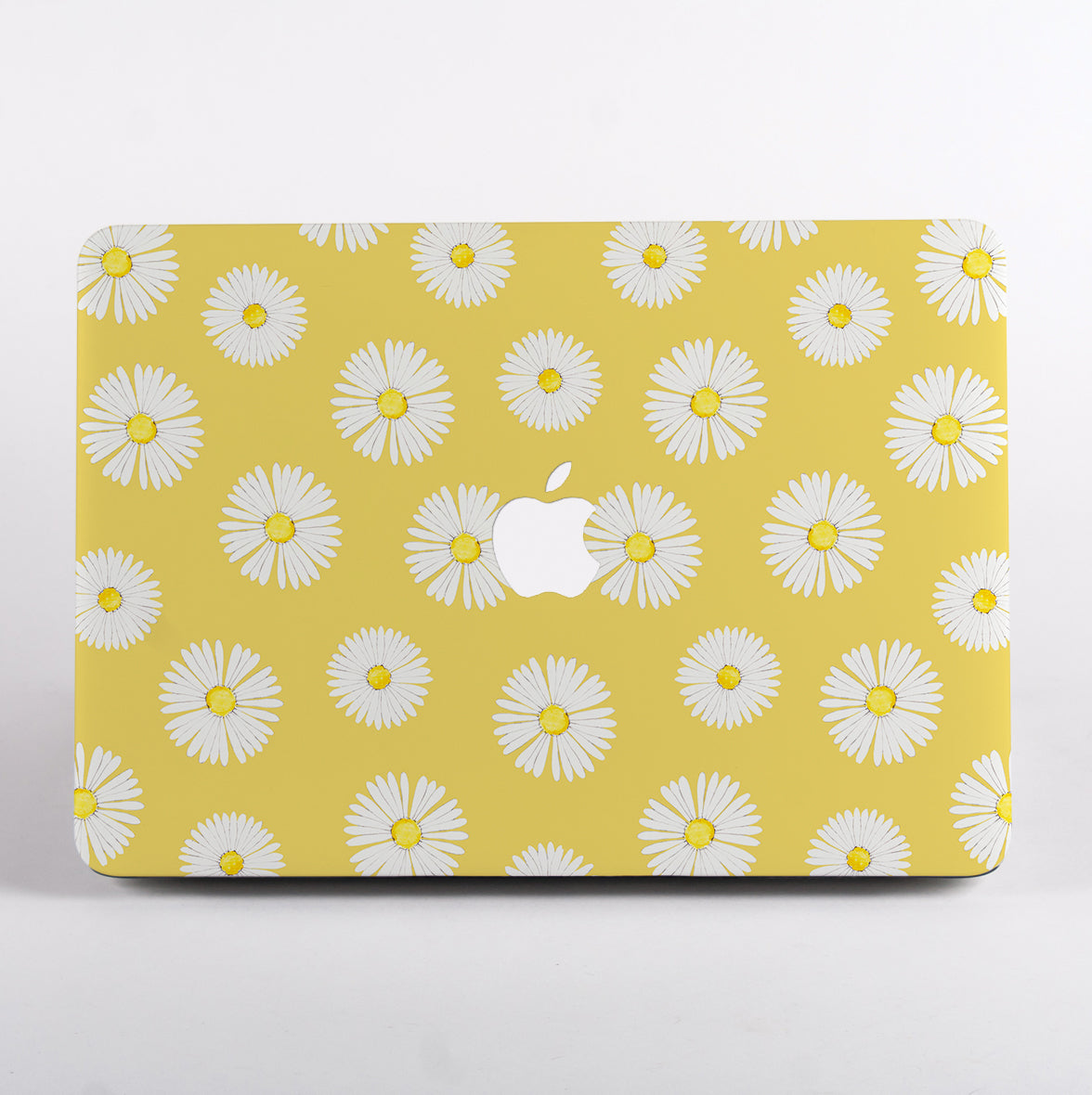 MacBook with a yellow case featuring white daisy pattern