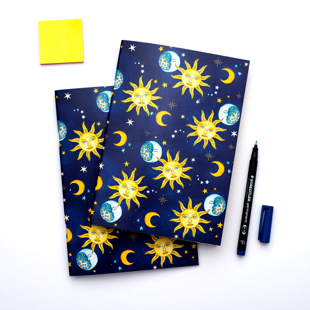 Two notebooks with celestial design on a white background