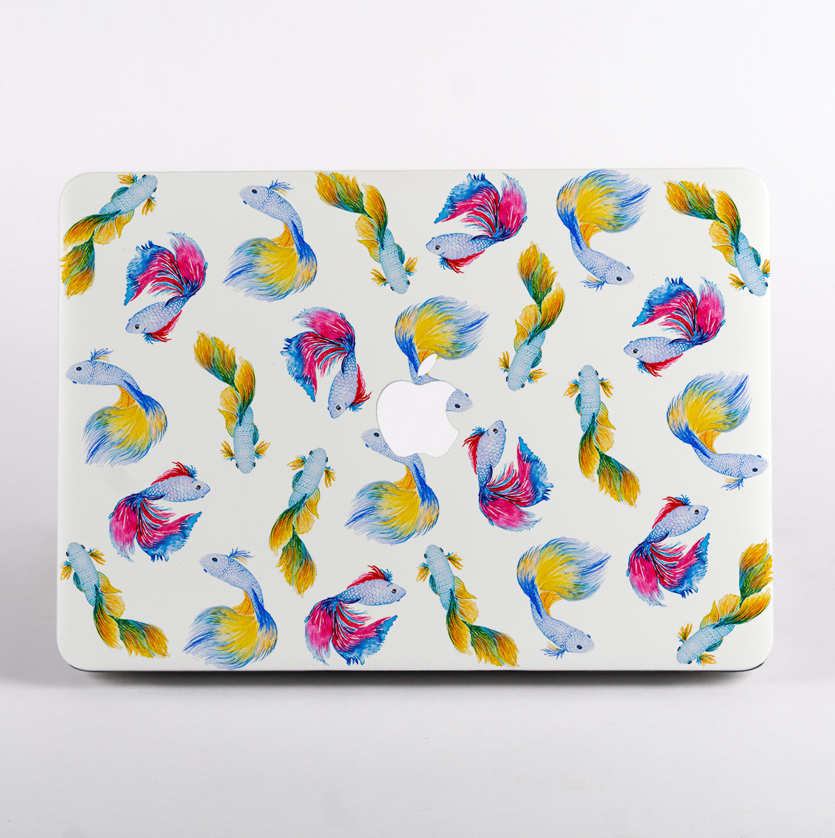 MacBook with colorful fish pattern on a white background