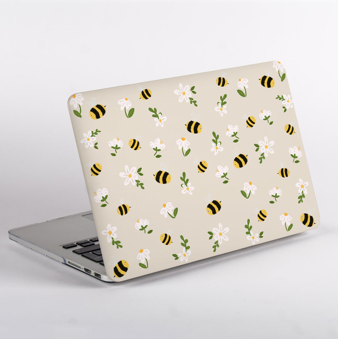 Side view of MacBook with a decorative case featuring bees and flowers on a beige background