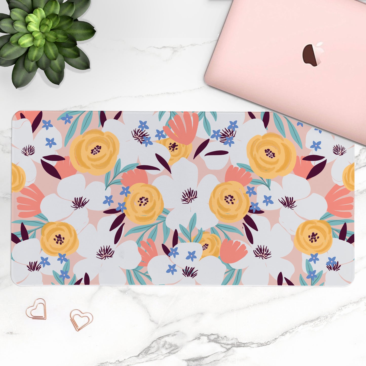 Floral patterned mouse pad on a marble surface with a laptop and plant.