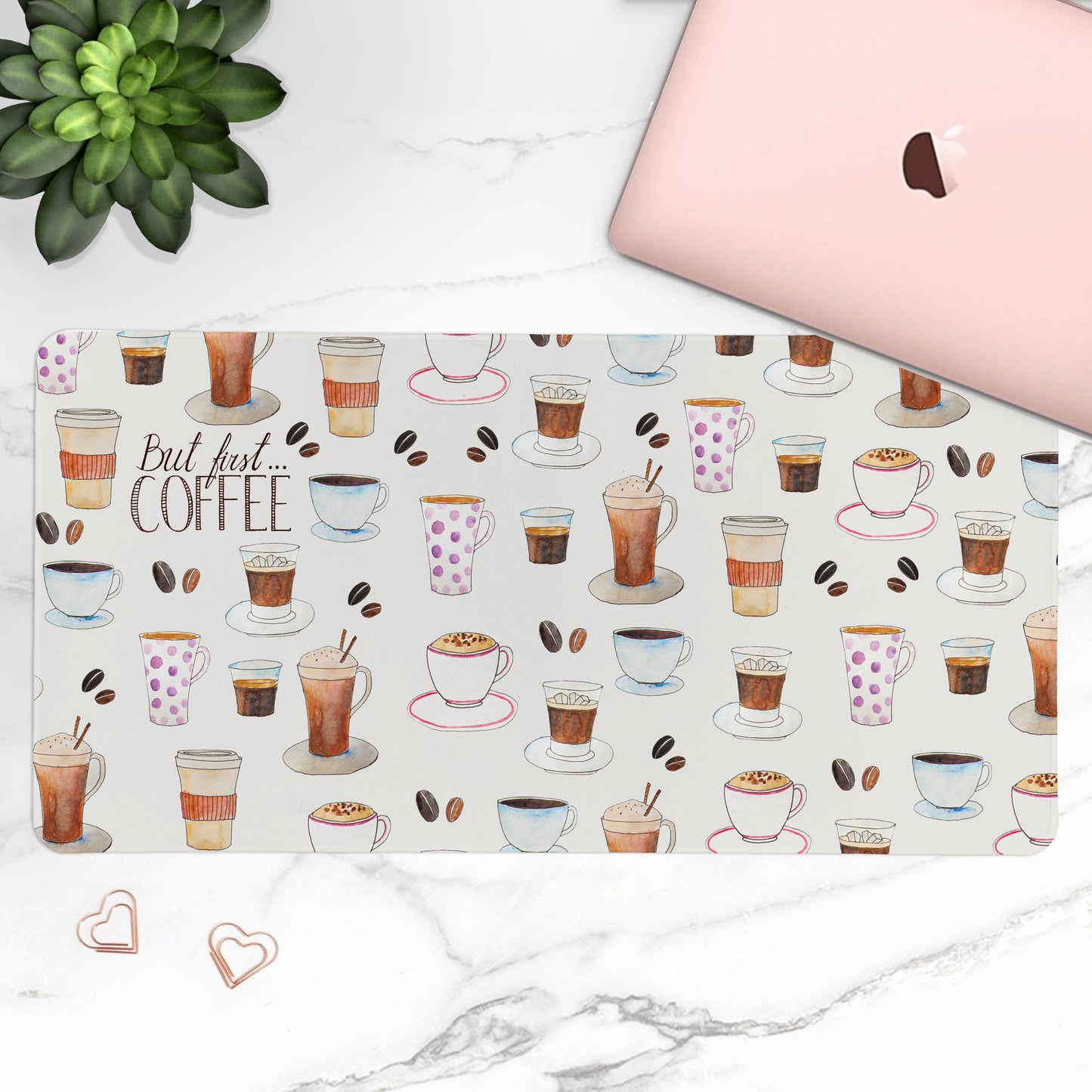 Laptop with a coffee-themed desk mat on a marble surface