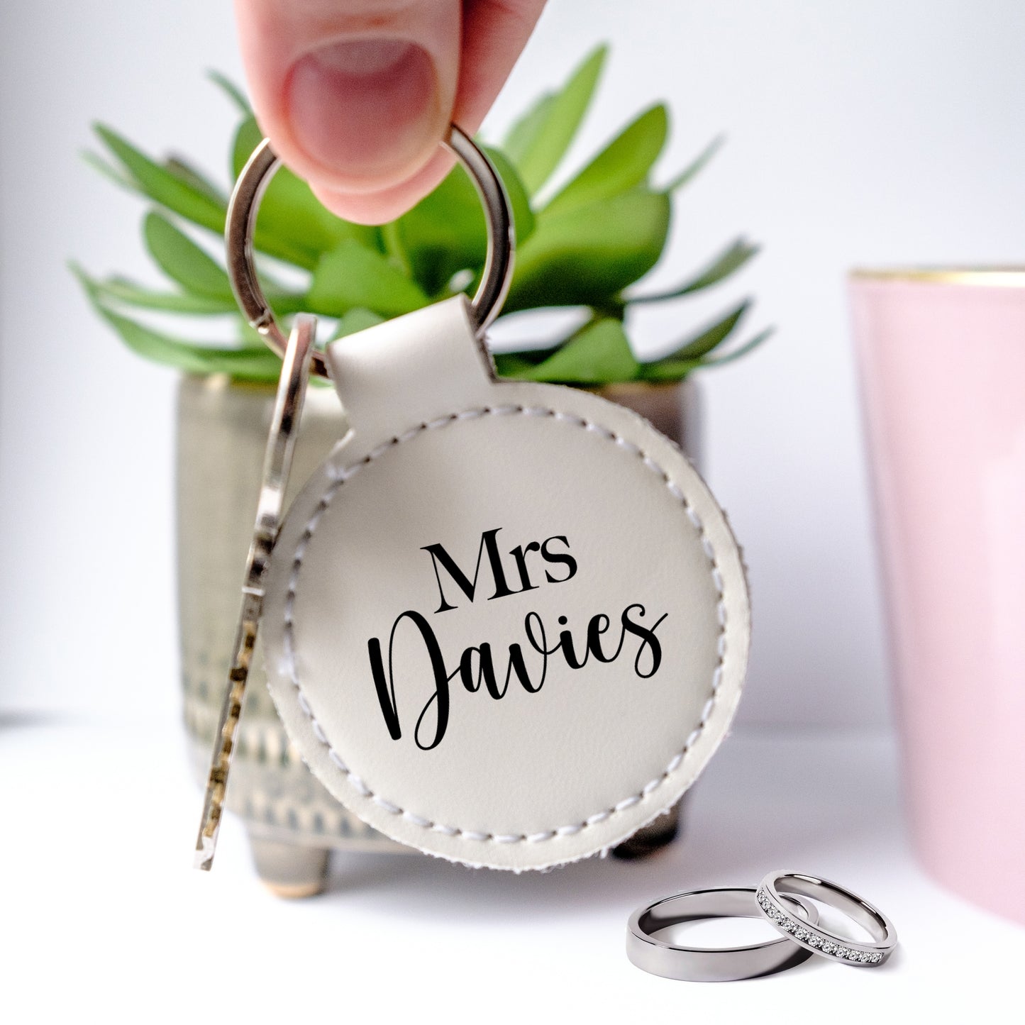 Round white letaher keyring with black writing Mrs and customised family name under
