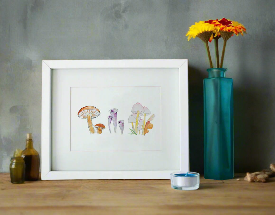 Framed artwork of mushrooms next to a teal vase with flowers on a beige background