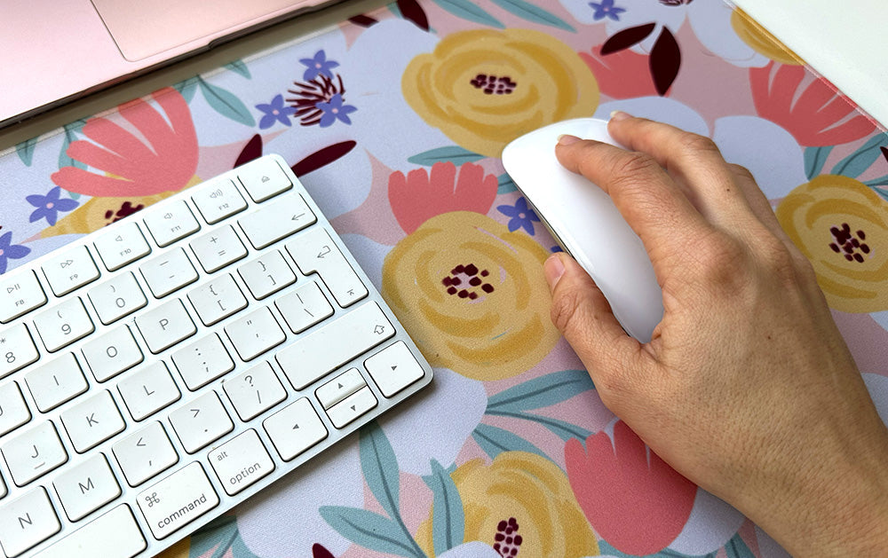 A large fabric desk mat with floral design used as a mouse pad for easy mouse movement