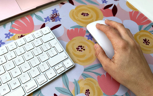 A large fabric desk mat with floral design used as a mouse pad for easy mouse movement