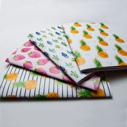Four notebooks with different patterns on a light gray background