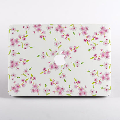 MacBook with a pink and white floral design case on a white background