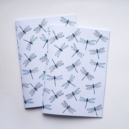 Two notebooks with dragonfly pattern on a white background