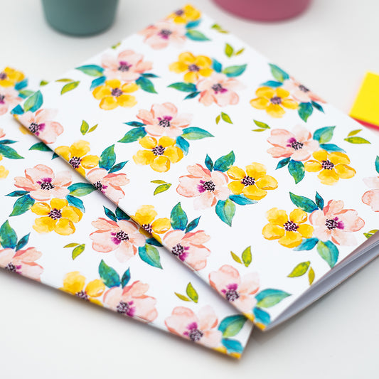 Floral patterned notebooks on a white surface