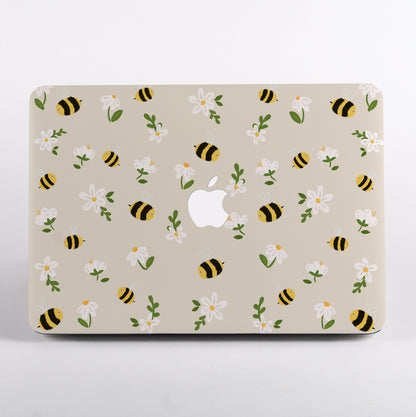 MacBook with a decorative case featuring bees and flowers on a beige background