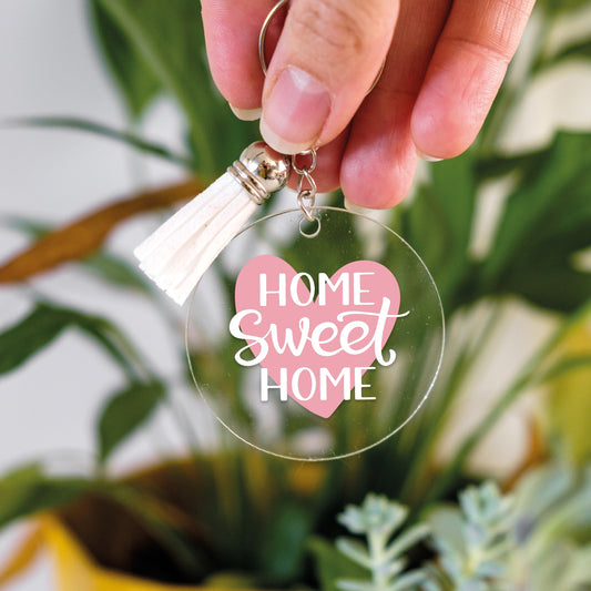 Clear acrylic keychain with 'Home Sweet Home' text and pink heart, held by a hand perfect for keeping keys organised.