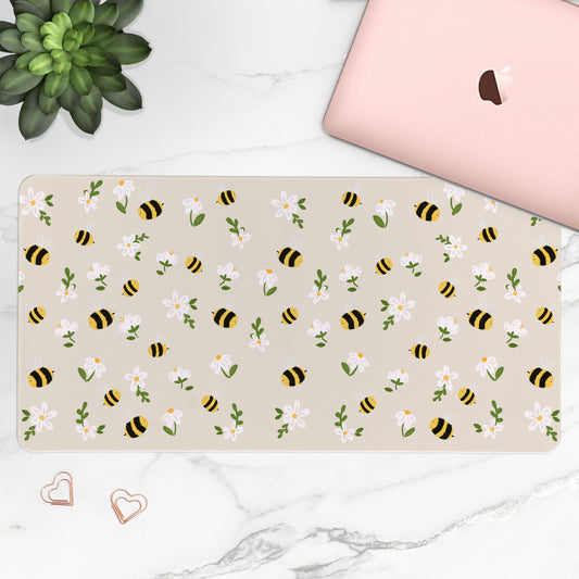 Beige desk mat with bee and flower pattern on a white surface