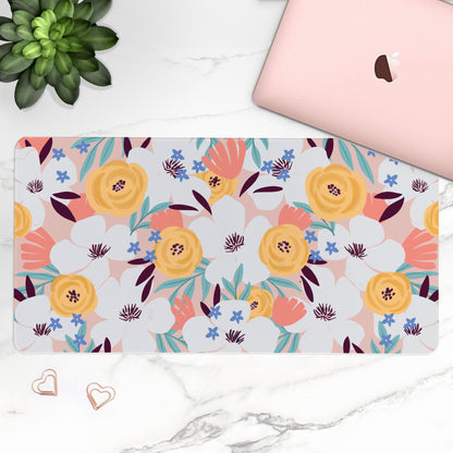 Floral patterned mouse pad on a marble surface with a laptop and plant.