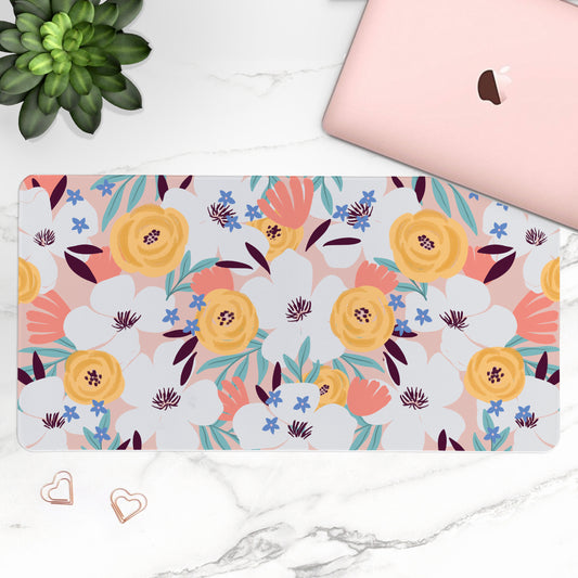 Floral patterned mouse pad on a marble surface with a laptop and plant.