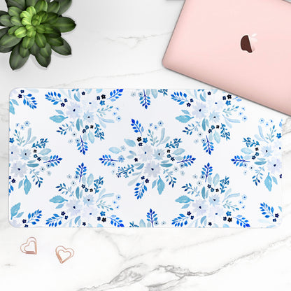 Floral patterned desk mat on a desk with a laptop and plant