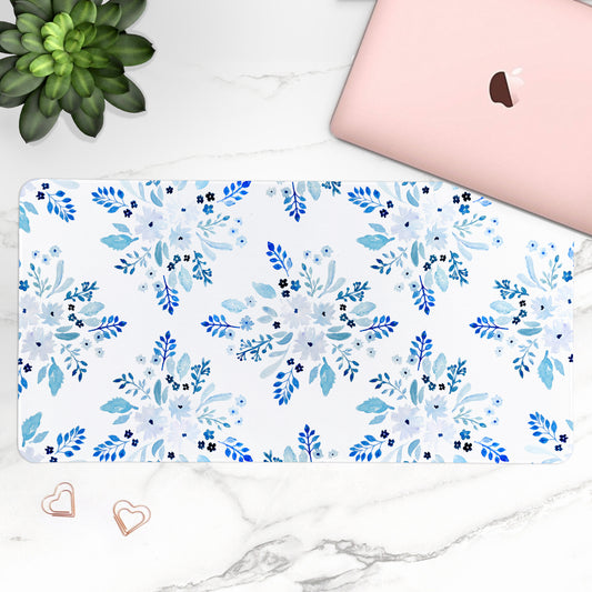 Floral patterned desk mat on a desk with a laptop and plant