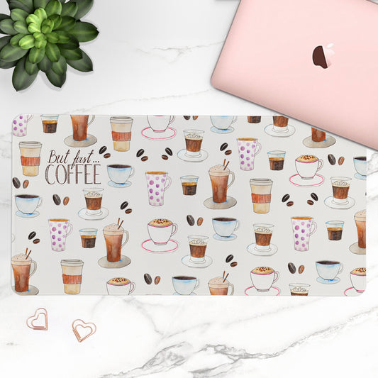 Laptop with a coffee-themed desk mat on a marble surface