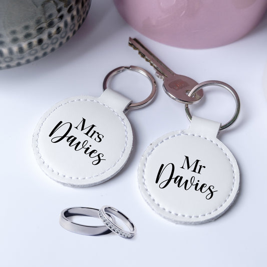 A set of two leather keyrings with black writing Mr and Mrs, personalised with the family name, perfect gift for newelyweds.