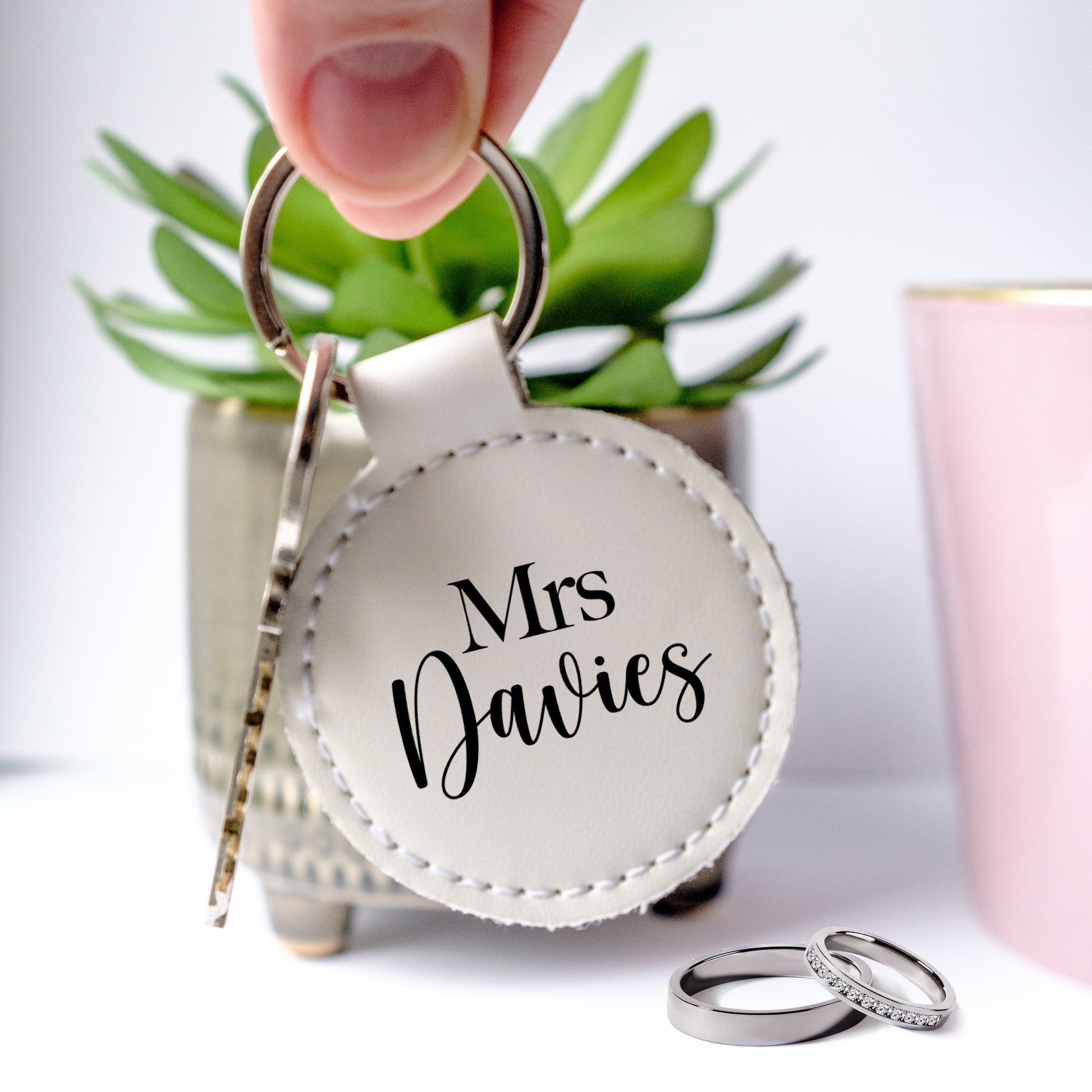 Round white letaher keyring with black writing Mrs and customised family name under