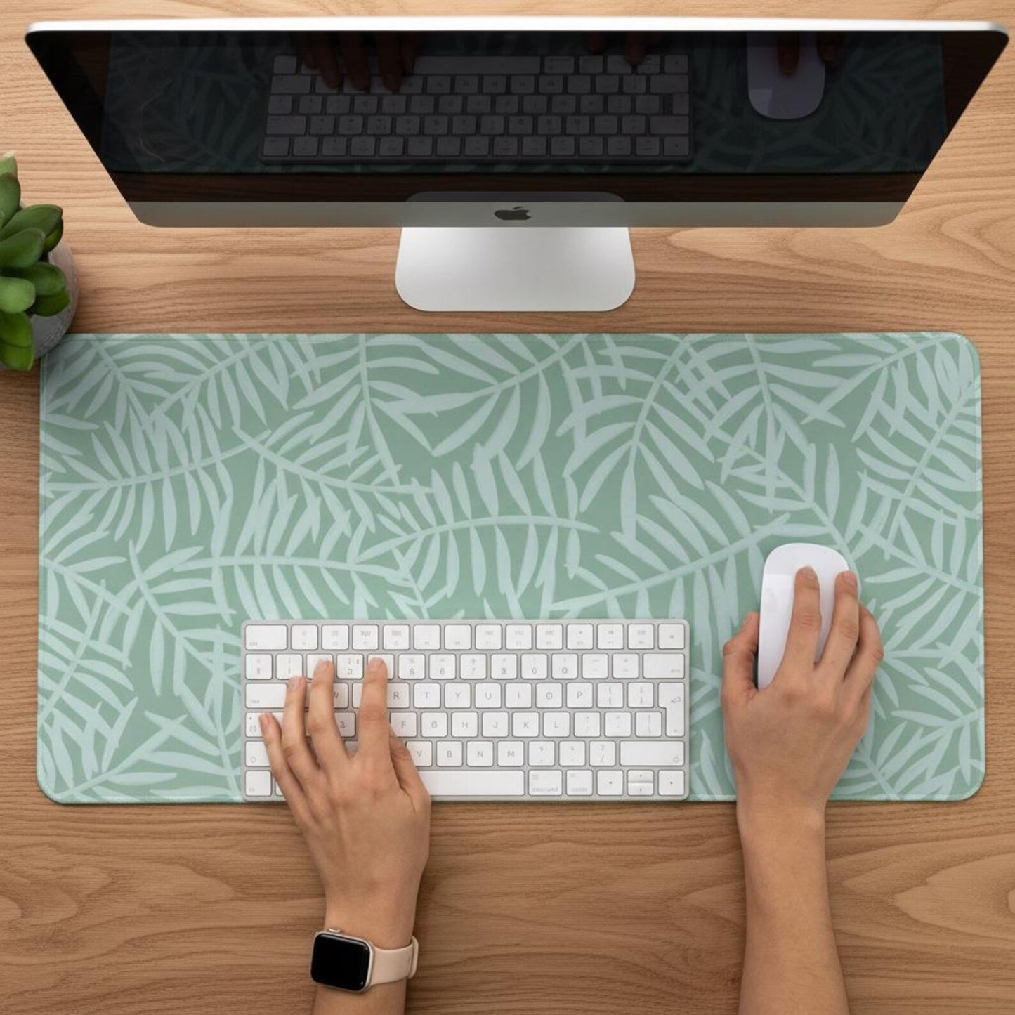 Person working on a desk with a Green Botanical Desk Mat