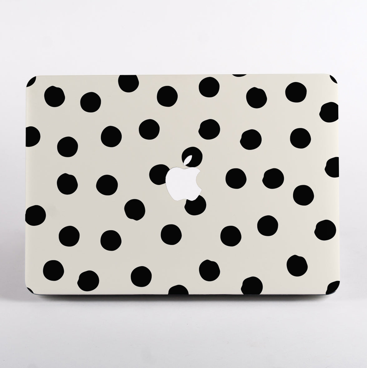 Painted dots MacBook Case featuting black hand drawn dots on a cream background and with Apple logo cutout.
