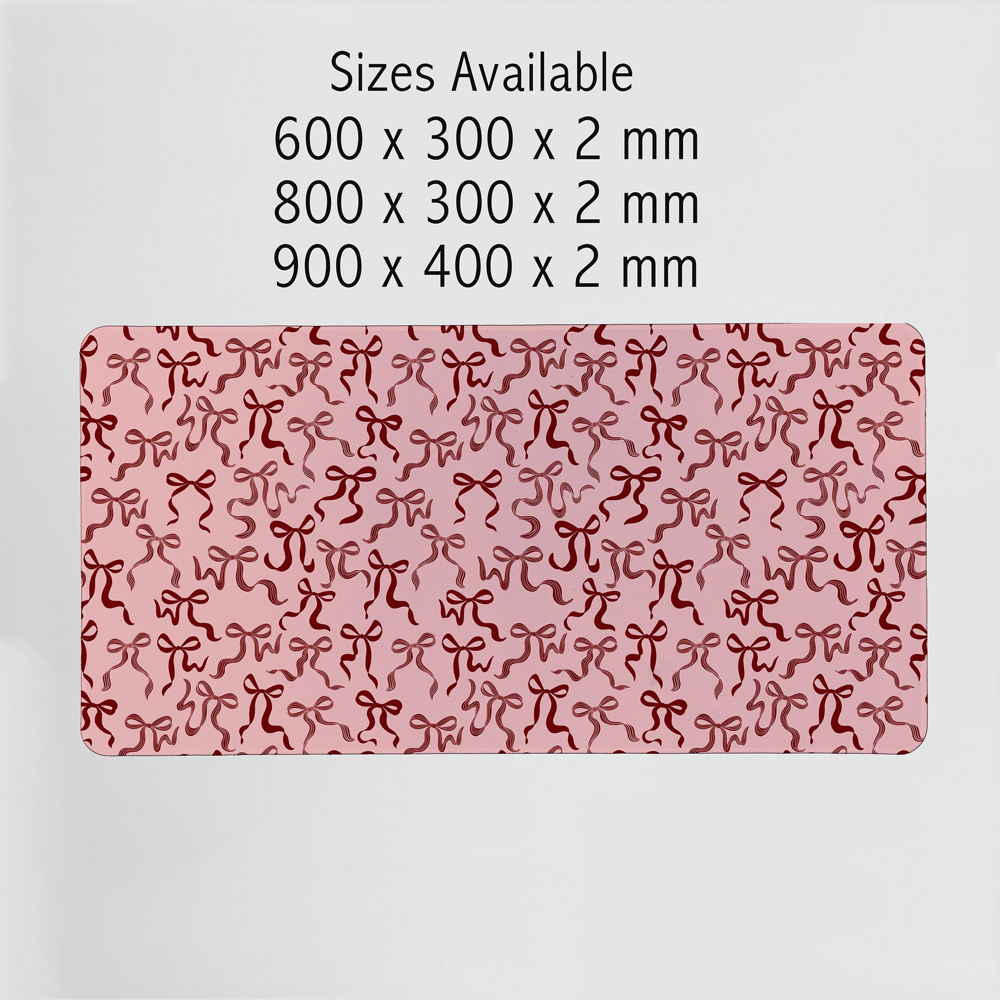 Ribbon bows desk mats in multiple sizes displayed flat on white background. Pretty and practical desk pads designed to fit any workspace aesthetic.