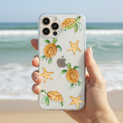 Phone case with turtle and starfish design held by a hand with ocean background