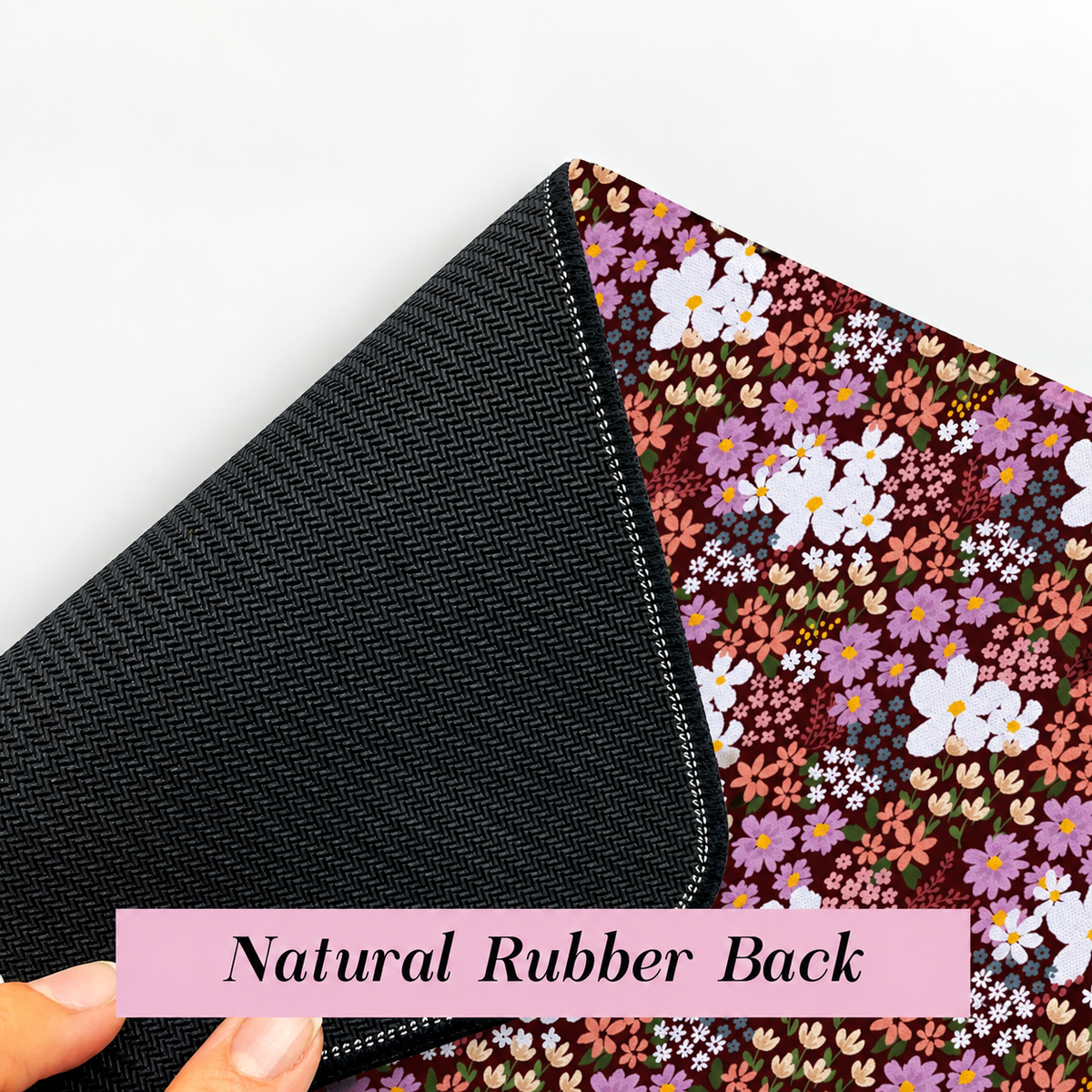 Floral desk mat with textured natural rubber backing and stitched edges for a non-slip desk surface.