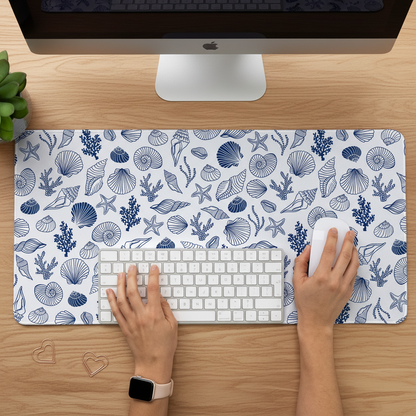 person working on a desk with Coastal Desk Mat featuring outlised blue sea shells for an aesthetic setup