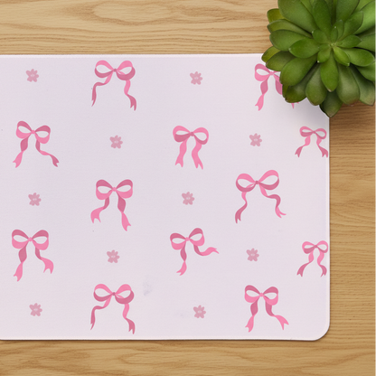 a close up shot of the pink ribbon bow desk mat showing stitched edges