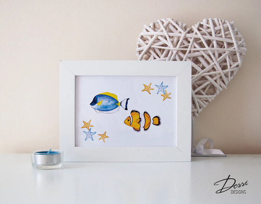 Framed artwork of two fish and stars on a white surface with a decorative heart and candle in the background.