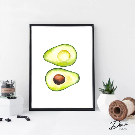 Framed artwork of a halved avocado on a white wall with decorative items below.