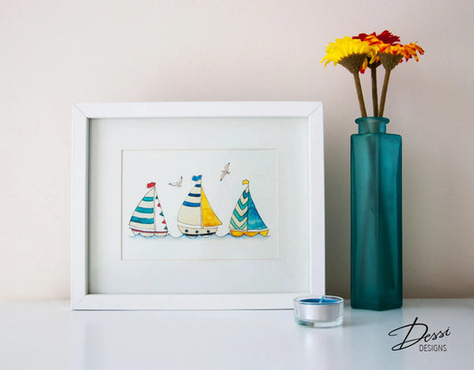 Framed artwork of colorful sailboats on a white surface with a teal vase and flowers.
