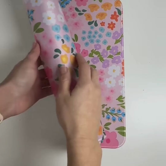 Video showing  large floral desk mat with cute colourful print, smooth surface, stitched edges and rubber base for an aesthetic desk setup.