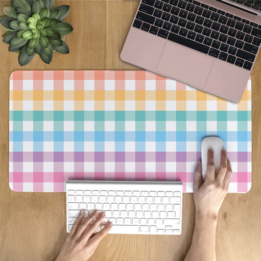 Colorful plain desk mat on a wooden desk with a laptop, keyboard, and mouse.