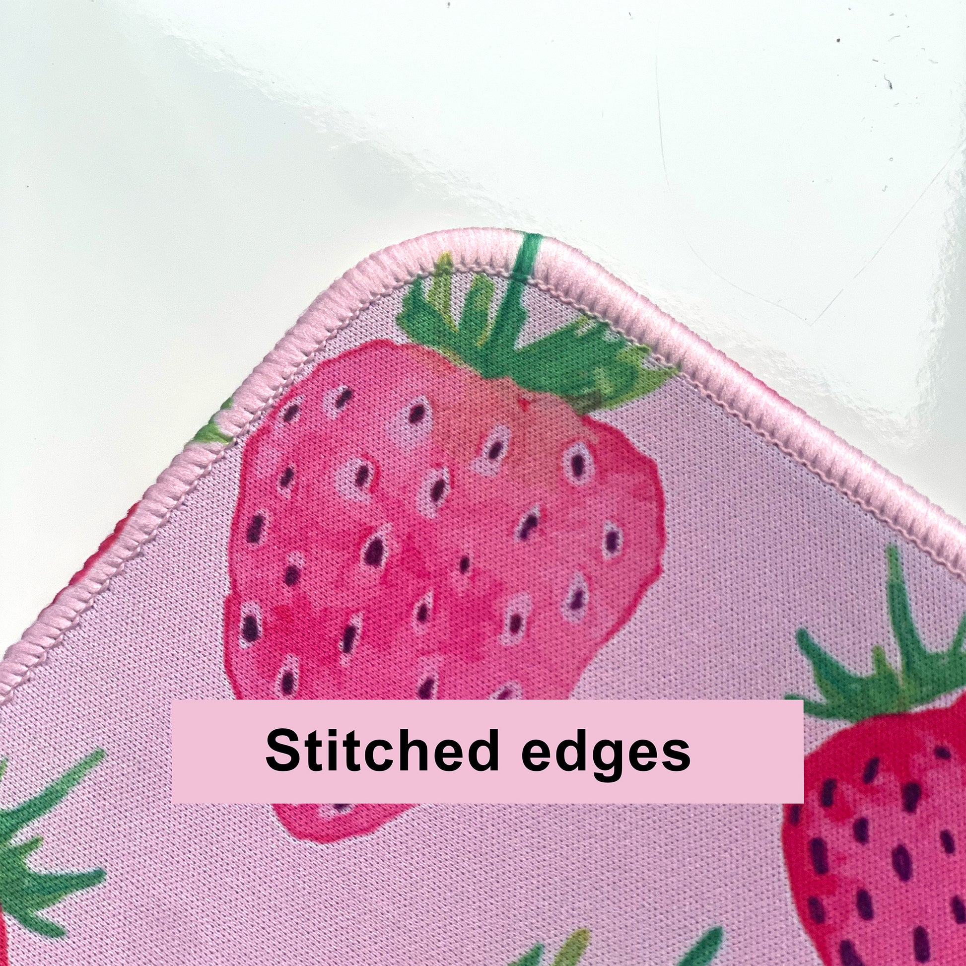 Desk mat with strawberry design and stitched edges