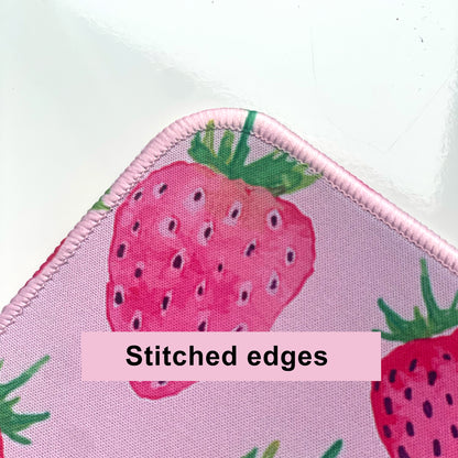 Desk mat with strawberry design and stitched edges