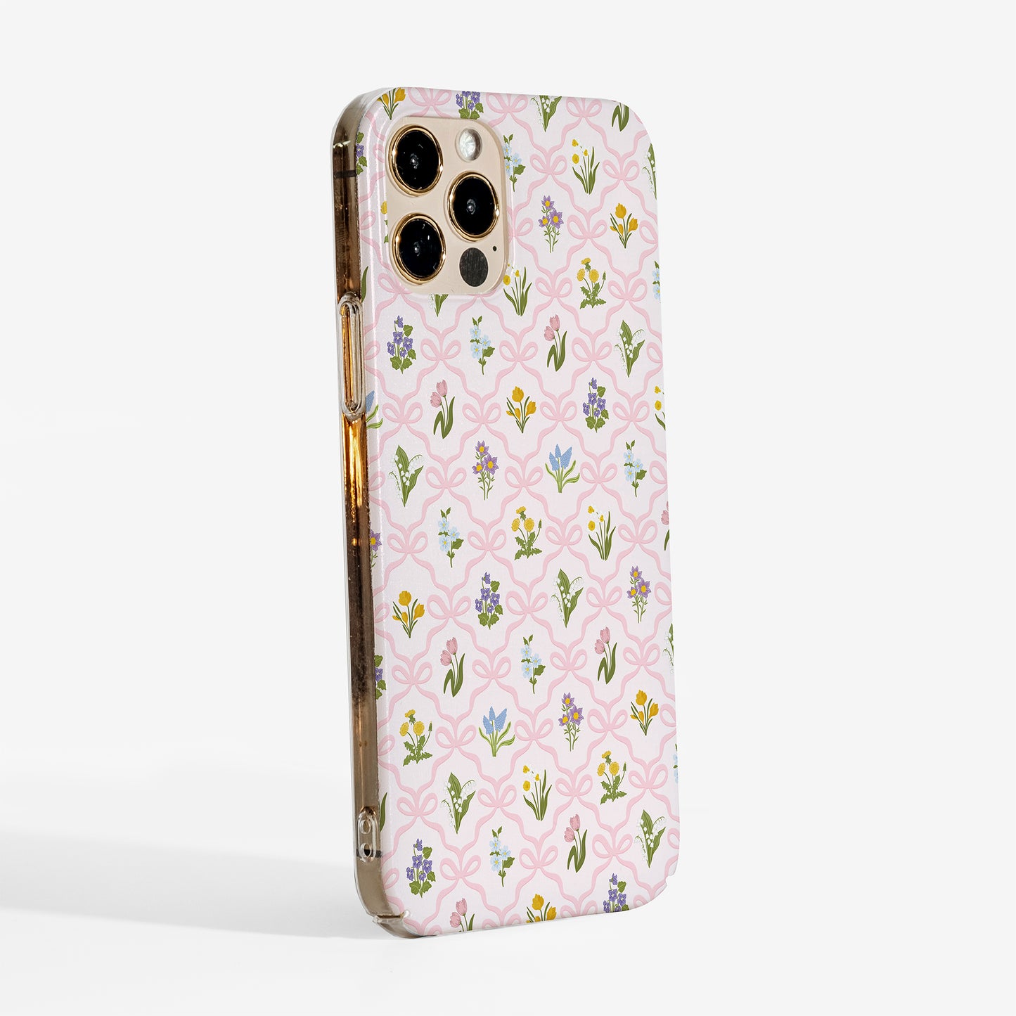 Side view of a floral phone case with a pink bow trellis design and vintage wildflowers printed on a slim hard plastic shell.
