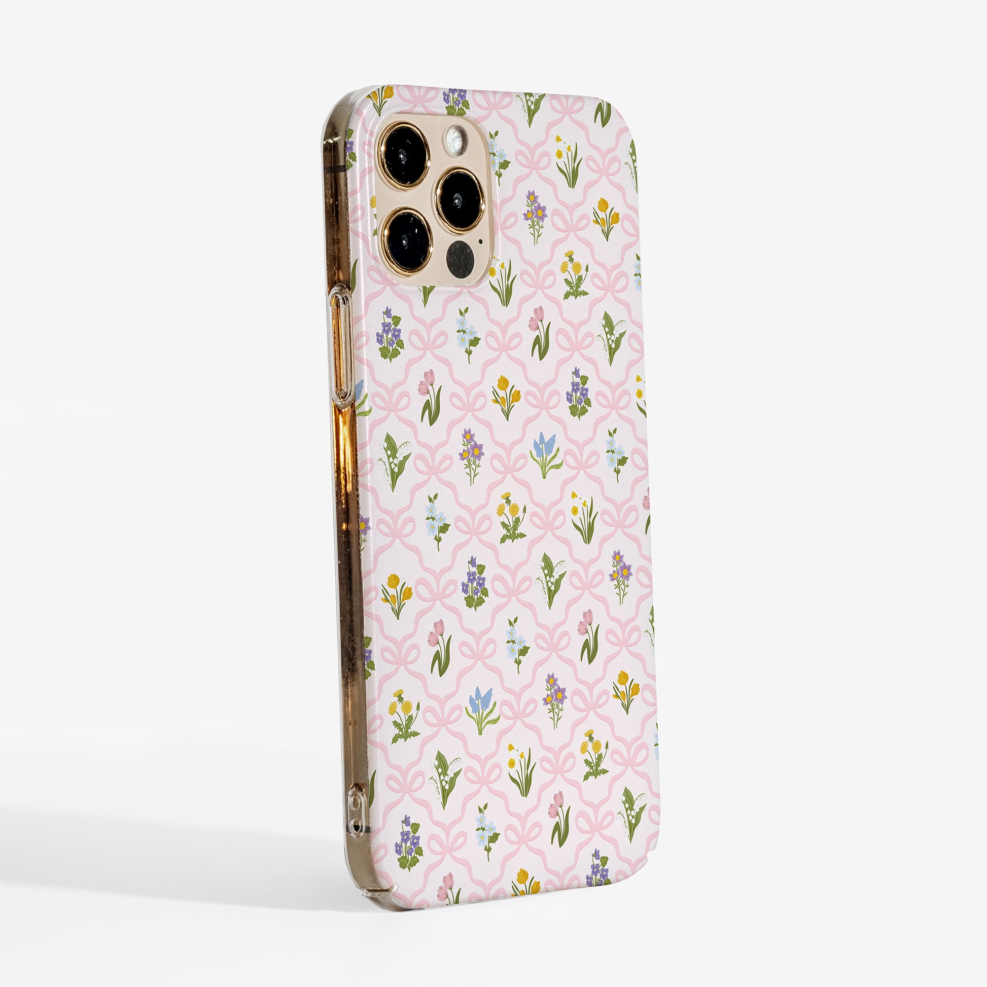 Side view of a floral phone case with a pink bow trellis design and vintage wildflowers printed on a slim hard plastic shell.