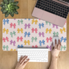 Cute Bow Desk mat featuring small colourful bowties on a pink background, perfect to personalise your space and add a layer of comfort. Available at www.dessi-designs.com